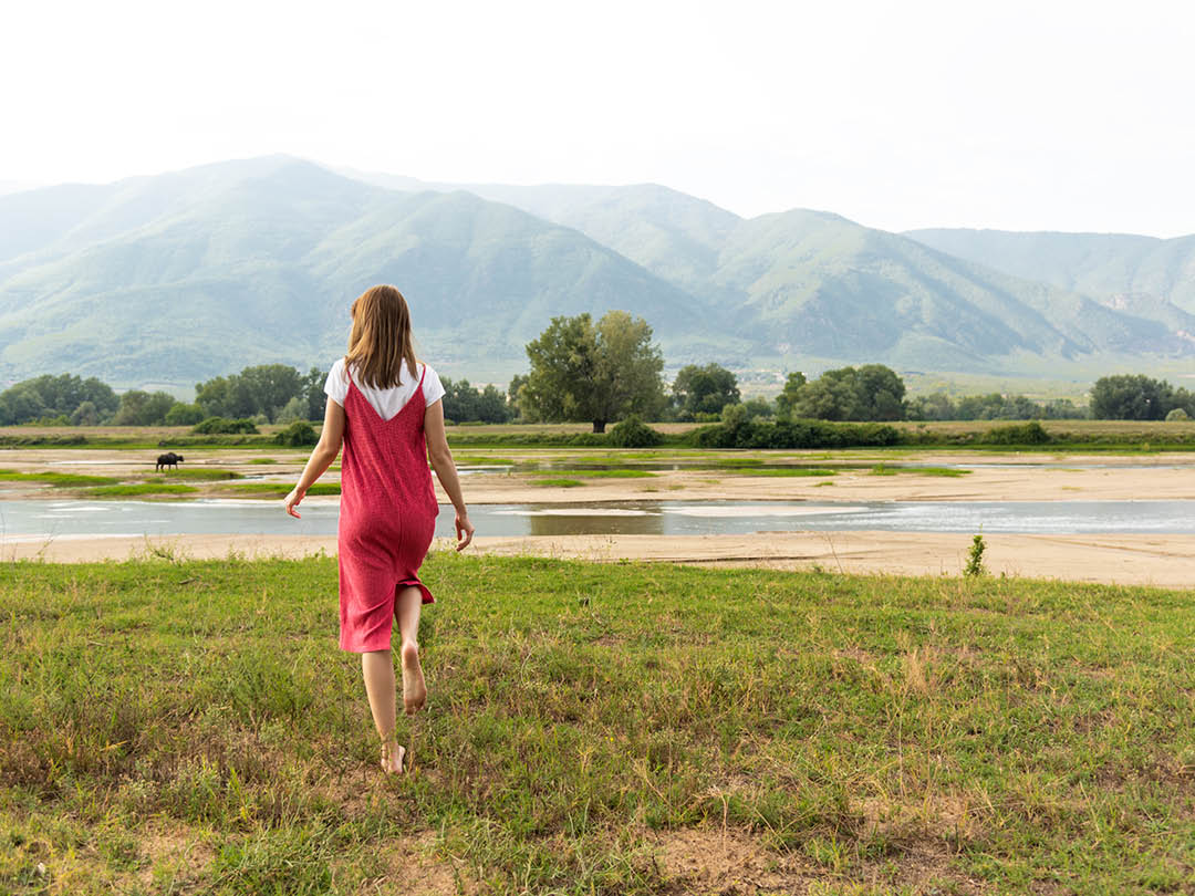 A woman walking barefoot on grass for ecotherapy and connecting to nature